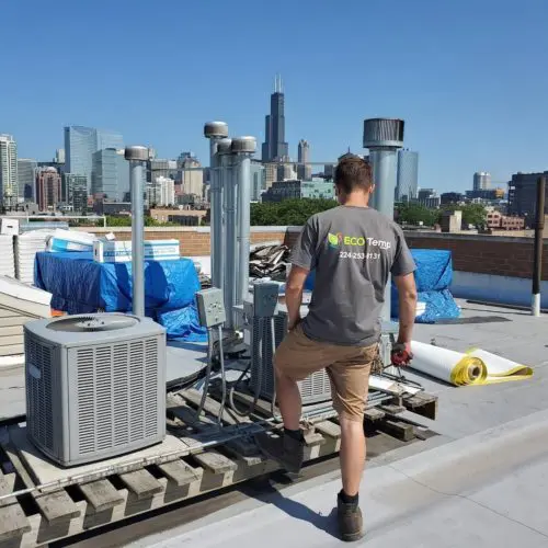 The owner of Eco Temp HVAC on a Chicago rooftop examined the AC units of a local restaurant.