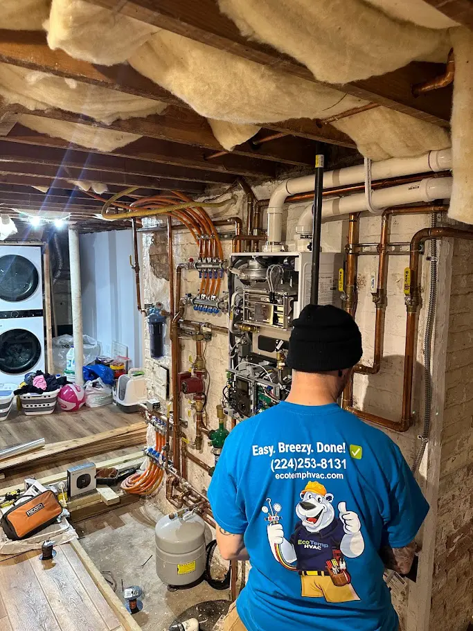 A technician repairing a Navian Boiler system in a basement.