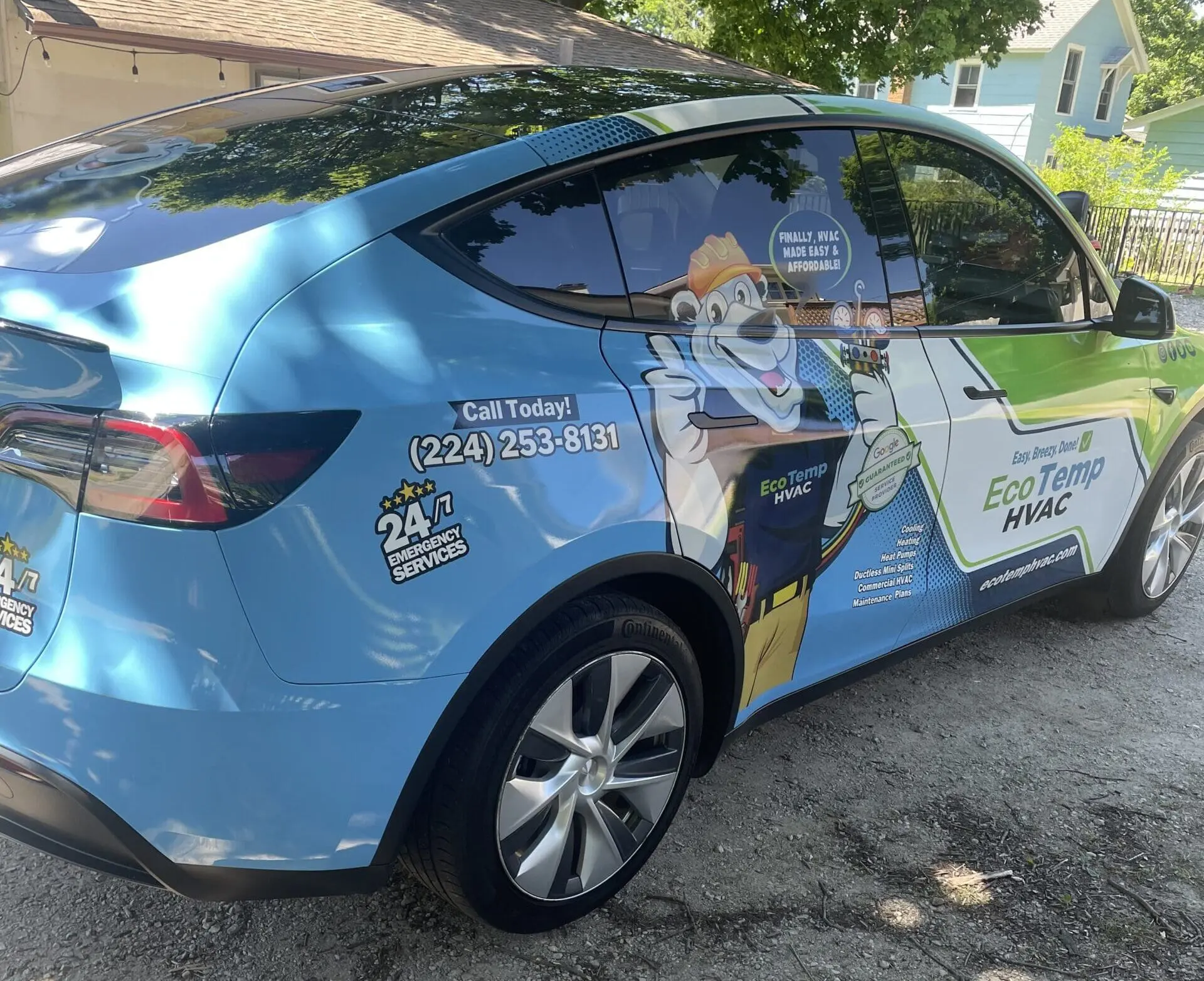 A car with a blue and green wrap on it with a polar bear on the side.