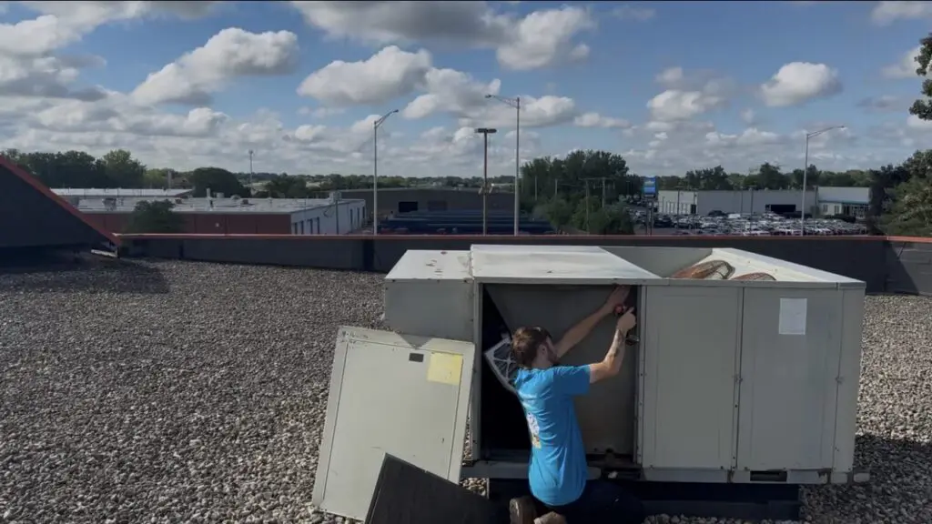 Commercial HVAC technician performing rooftop unit maintenance on a commercial building in Chicago, Illinois