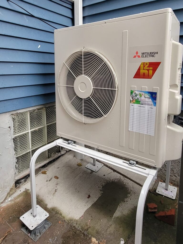 Air source heat pump mini split installation in Elgin IL featuring Mitsubishi Electric outdoor unit mounted on elevated stand for residential HVAC system